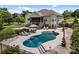 This backyard features a kidney-shaped pool, stone patio, lounge chairs, and a screened-in porch at 1115 Wynnbrook Way, Concord, NC 28027