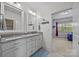 Bright bathroom featuring double vanity, granite countertop, and an open doorway to the bedroom at 1115 Wynnbrook Way, Concord, NC 28027