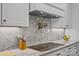 Close-up of the cooktop with marble backsplash and pot filler faucet at 1115 Wynnbrook Way, Concord, NC 28027