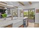 Kitchen island with farmhouse sink, marble countertop, and view to the outdoor deck at 1115 Wynnbrook Way, Concord, NC 28027