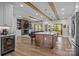 Open-concept kitchen with a spacious island, wooden beams, and seamless flow to the living area at 1115 Wynnbrook Way, Concord, NC 28027