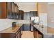 Detailed kitchen shot with granite countertops, dark cabinets, stainless appliances, and sleek hardware at 11209 Lazio Ln # 1, Charlotte, NC 28277