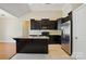 A well-lit kitchen with granite countertops, dark cabinets, stainless steel appliances, and a kitchen island at 11209 Lazio Ln # 1, Charlotte, NC 28277