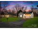 Charming single-Gathering home with green lawn and paved driveway at dusk at 1129 Thayer Glen Ct, Charlotte, NC 28213