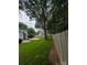 View of a grassy backyard with mature trees and a glimpse of a light blue house at 117 Blackberry Ln # 66, Mooresville, NC 28117