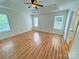 Spacious bedroom with wood flooring, a tray ceiling, a fan, and three windows for ample light at 117 Blackberry Ln # 66, Mooresville, NC 28117