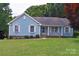 Charming blue home with white trim, lush lawn, and a welcoming front entrance with decorative window boxes at 117 Blackberry Ln # 66, Mooresville, NC 28117