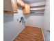 Laundry area showcasing upper cabinets, floating shelves, and laminate floors with washer and dryer hookups at 117 Blackberry Ln # 66, Mooresville, NC 28117