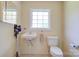 Well-lit bathroom with simple vanity, toilet, and window at 1184 Cambridge Dr, Shelby, NC 28152