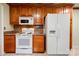 A kitchen featuring wooden cabinetry, white appliances, and tiled floors, offering a functional cooking space at 1184 Cambridge Dr, Shelby, NC 28152