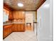A kitchen boasts wooden cabinets, tiled floors, and a view into the dining area, perfect for Gathering meals at 1184 Cambridge Dr, Shelby, NC 28152