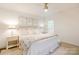 Bright bedroom features neutral decor, a ceiling fan, and a comfortable bed with decorative pillows and floral-patterned throw at 1184 Thornwell Ave, Rock Hill, SC 29732