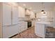 Bright kitchen featuring white cabinets with brass hardware, herringbone flooring, and stainless steel appliances at 1184 Thornwell Ave, Rock Hill, SC 29732