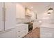 Well-lit kitchen with white cabinetry, black range, and a spacious central island with marble countertops at 1184 Thornwell Ave, Rock Hill, SC 29732