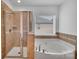 Bright bathroom with a glass enclosed shower and soaking tub at 1225 Madison Green Dr, Fort Mill, SC 29715