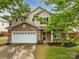 Charming two-story home featuring a stone facade, attached two-car garage, and beautifully landscaped front yard at 1225 Madison Green Dr, Fort Mill, SC 29715