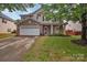 Two-story home with stone accents, a well-maintained lawn, and an attached two-car garage at 1225 Madison Green Dr, Fort Mill, SC 29715