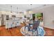 A kitchen with hardwood floors, an island with bar stool seating, stainless steel appliances, and a table at 1225 Madison Green Dr, Fort Mill, SC 29715