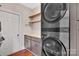 Laundry room with a stacked washer and dryer, wood countertop, cabinets, and shelves at 1225 Madison Green Dr, Fort Mill, SC 29715