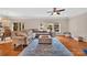 A living room with hardwood floors, large windows, a comfortable couch, ceiling fan and decor at 1225 Madison Green Dr, Fort Mill, SC 29715