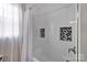 Modern bathroom featuring a tiled shower with a shower curtain and window for natural light at 12416 Kane Alexander Dr, Huntersville, NC 28078