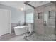 Bathroom featuring a freestanding tub, stylish tiling, and a glass-enclosed shower at 12416 Kane Alexander Dr, Huntersville, NC 28078