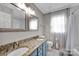 Bathroom features a double vanity with granite countertops, blue cabinets and tile flooring at 12416 Kane Alexander Dr, Huntersville, NC 28078