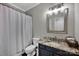 Well-lit bathroom with granite countertop, decorative mirror, and shower/tub combo at 12416 Kane Alexander Dr, Huntersville, NC 28078