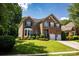 Beautiful brick home with a manicured lawn, bay window, two-car garage, and blue shutters at 12416 Kane Alexander Dr, Huntersville, NC 28078