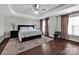 Elegant bedroom featuring tray ceilings, hardwood floors, and a cozy, inviting atmosphere at 12416 Kane Alexander Dr, Huntersville, NC 28078
