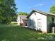 View of the backyard with a home and additional building structure, set beneath a blue sky at 125 Hunter St, Salisbury, NC 28144