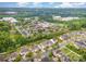 A stunning aerial view of a Primary-planned community with lush landscaping and a commercial business park adjacent at 12832 Heath Grove Dr, Huntersville, NC 28078