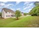 Lush backyard with green lawn, white picket fence, and mature trees offering shade at 12832 Heath Grove Dr, Huntersville, NC 28078