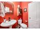 Cozy half-bathroom featuring a pedestal sink, decorative mirror, and charming wall-mounted storage at 12832 Heath Grove Dr, Huntersville, NC 28078