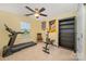 Well-equipped home gym with treadmill, weights, fan, and natural light for effective workouts at 12832 Heath Grove Dr, Huntersville, NC 28078