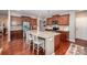 Modern kitchen with stainless steel appliances, island seating, and hardwood floors at 12832 Heath Grove Dr, Huntersville, NC 28078
