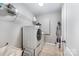 Clean laundry room with a stacked washer and dryer, shelving and tile floors at 12832 Heath Grove Dr, Huntersville, NC 28078