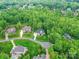 Aerial view of the neighborhood showcasing the home surrounded by mature trees and lush landscaping at 129 Overlook Ridge Ln, Davidson, NC 28036
