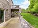View of the outdoor living space with a stone patio, wooden deck and steps to the lush green lawn at 129 Overlook Ridge Ln, Davidson, NC 28036