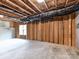 Unfinished basement features a window and exposed wood framing, awaiting customization at 129 Overlook Ridge Ln, Davidson, NC 28036