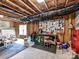 Unfinished basement with exposed ceiling with a tool bench, chair, and organization system at 129 Overlook Ridge Ln, Davidson, NC 28036