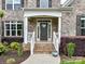 Close-up of the home's entrance with a brick facade and welcoming front porch at 129 Overlook Ridge Ln, Davidson, NC 28036
