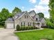 Charming two-story brick home with a well-manicured lawn, lovely landscaping, and a two-car garage at 129 Overlook Ridge Ln, Davidson, NC 28036