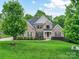 Beautiful brick home with a well-kept lawn, mature landscaping, and a welcoming front porch at 129 Overlook Ridge Ln, Davidson, NC 28036
