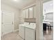 Bright laundry room with storage cabinets and views into the modern kitchen space at 129 Overlook Ridge Ln, Davidson, NC 28036