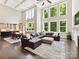 View of the open concept living room with fireplace, tall windows, and seamless flow to dining area at 129 Overlook Ridge Ln, Davidson, NC 28036