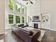 Living room featuring a brick fireplace, and tall windows bringing natural light to the open space at 129 Overlook Ridge Ln, Davidson, NC 28036