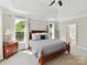 Bright main bedroom featuring tray ceilings, plush carpet, and an ensuite bathroom at 129 Overlook Ridge Ln, Davidson, NC 28036