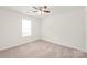 Bright bedroom with neutral carpet, ceiling fan, and natural light from the window at 13408 Golden Apple Ct, Charlotte, NC 28215