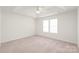 Spacious, carpeted bedroom with a tray ceiling and natural light from two windows at 13408 Golden Apple Ct, Charlotte, NC 28215